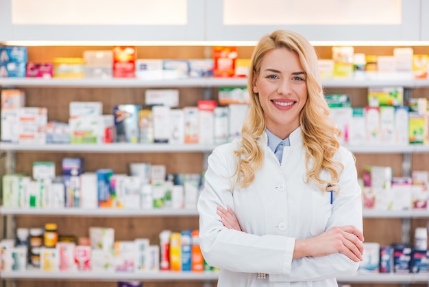 Foto bella donna che indossa in camice bianco che lavora in farmacia.
