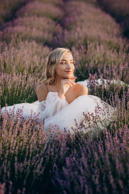 Foto bella donna in abito da sposa in campo di lavanda