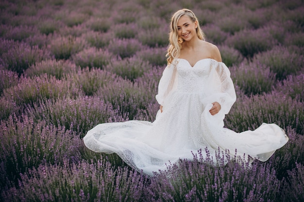 Beautiful woman in wedding dress in lavender field