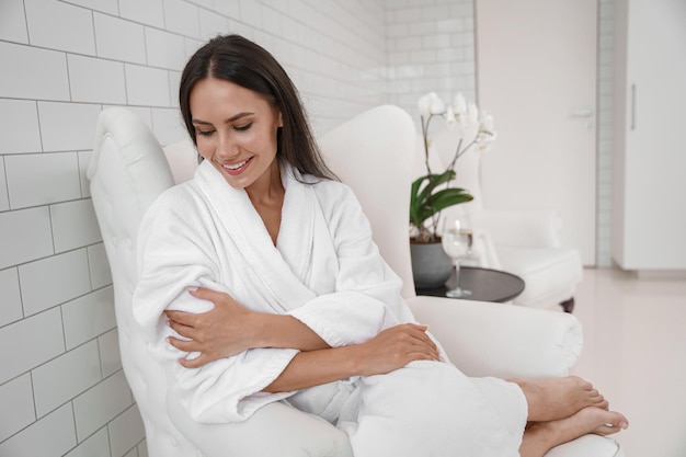 Beautiful woman in white bathrobe relaxing during medical
procedure in beauty clinic