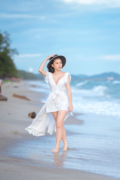 Beautiful woman in white dress on the beach