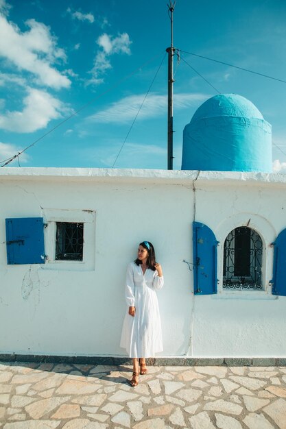 Photo beautiful woman in white dress near old greece church