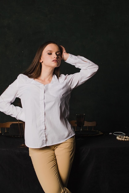 Beautiful woman in a white shirt on a black background