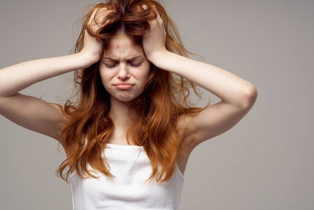 Beautiful woman in a white tshirt pimples on the face light\
background