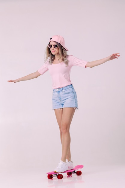 beautiful woman in white tshirt with pink skateboard