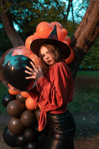 Beautiful woman in witch costume holding a balloon in her hands.Halloween, Black Friday
