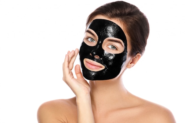 Фото Красивая женщина с очищающей черной маской на лице