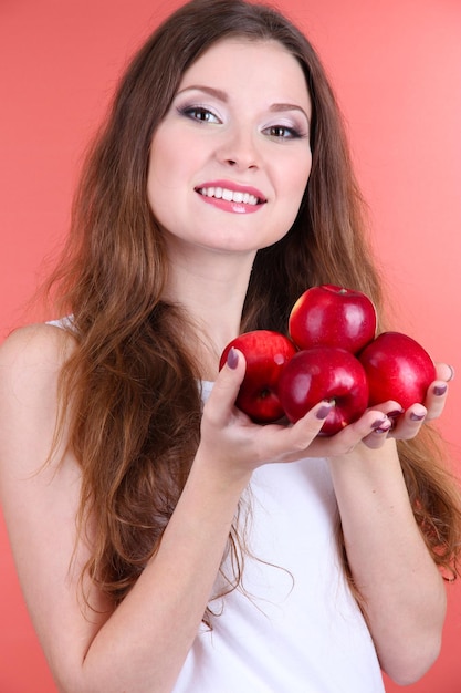 Photo beautiful woman with apples on pink background