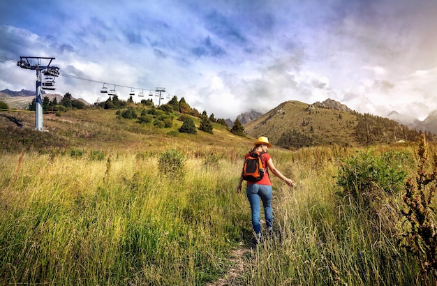 Beautiful woman with backpack in the mountains