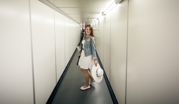 Foto bella donna con le borse che cammina al cancello d'imbarco all'aeroporto