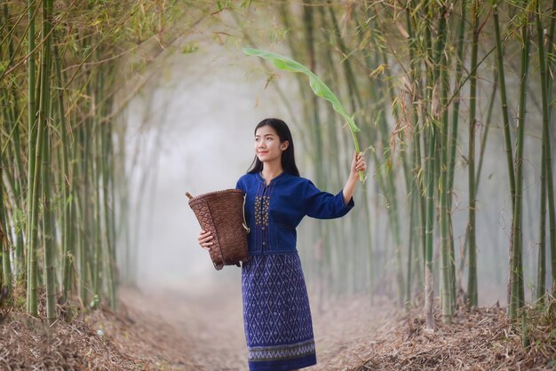 Photo beautiful woman with basket standing by tree