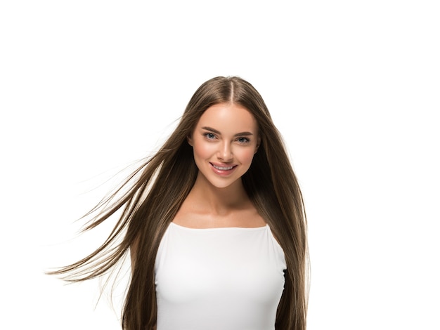 Beautiful woman with beautiful long smooth flying hair in white dress over color background