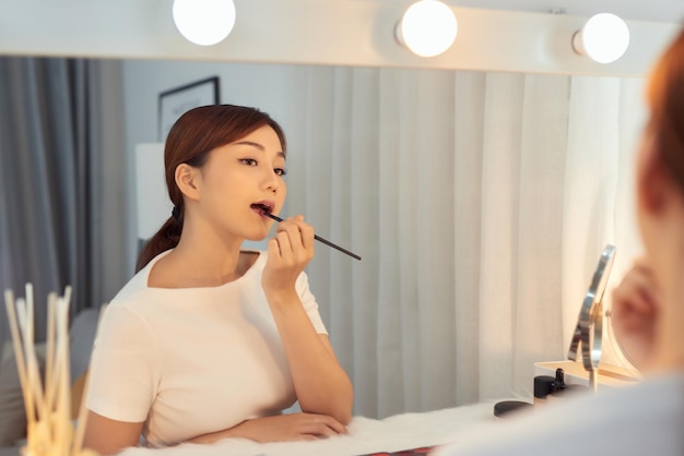 Beautiful Woman With Beauty Face Applying Lip Balm Lipcare Stick On Lips skincare cosmetics concept