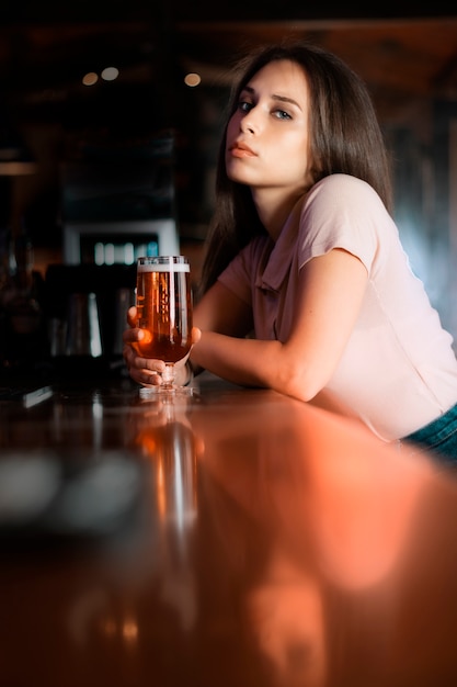 彼女の手でビールを持つ美しい女性