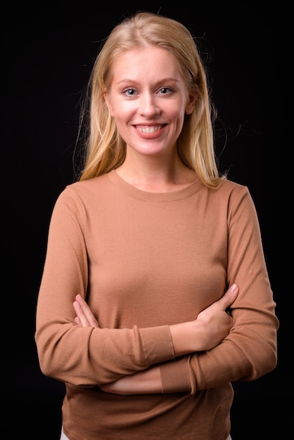 beautiful woman with blond hair wearing sweater on black