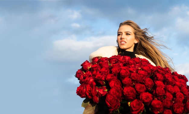 Beautiful woman with blooming rose flowers girl with rose bouquet outdoor