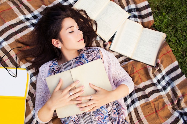 Foto bella donna con libri nel parco