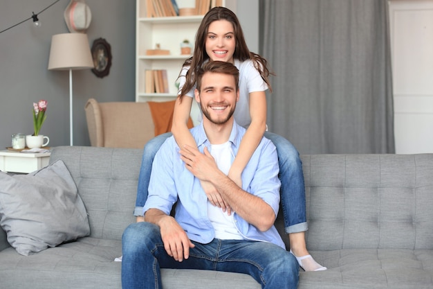 Beautiful woman with boyfriend spending quality time together on sofa at home in the living room.