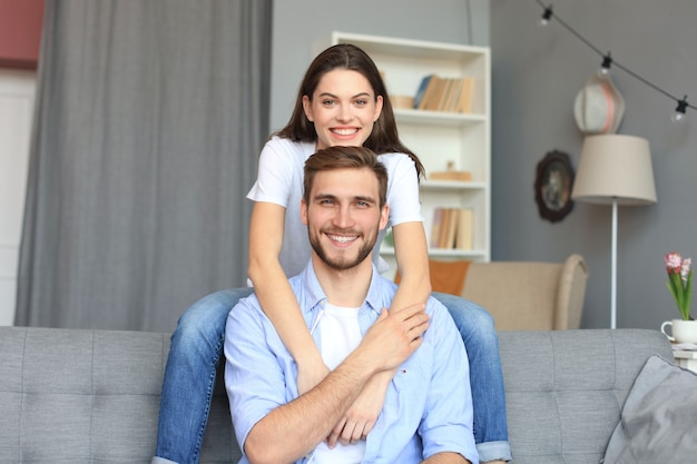 Beautiful woman with boyfriend spending quality time together on sofa at home in the living room.