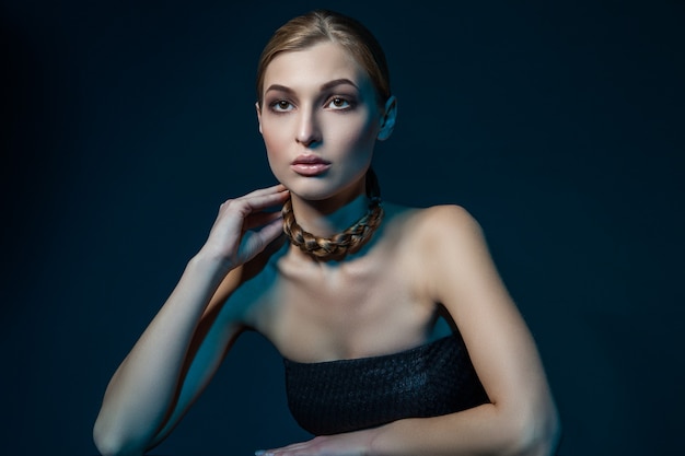 Beautiful woman with braid around her necklace. Horizontal studio shot