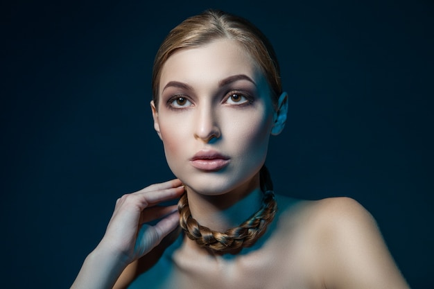 Beautiful woman with braid around her necklace. Horizontal studio shot