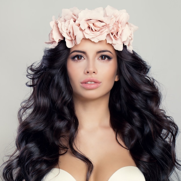 Красивая женщина с коричневыми волосами и цветками весенних роз. Весенняя красота