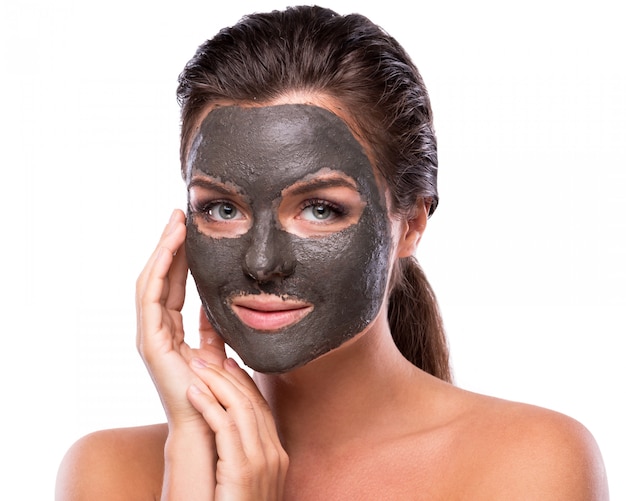 Beautiful woman with a clay or a mud mask on her face