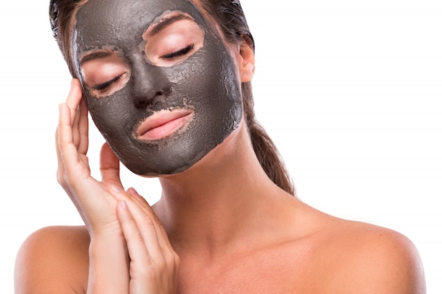 Beautiful woman with a clay or a mud mask on her face