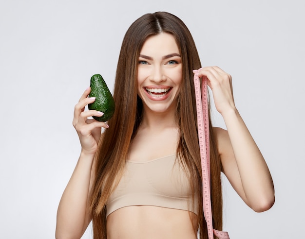 Beautiful Woman with Clean Fresh Skin holding avocado