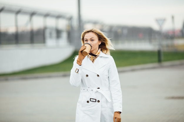 Photo beautiful woman with coffee cup near office building.