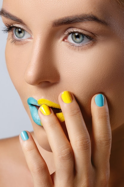 Beautiful woman with colorful nails and lips