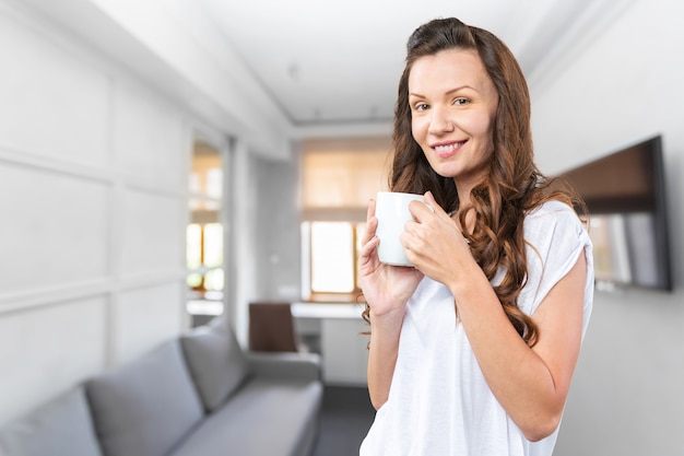 お茶のカップを持つ美しい女性