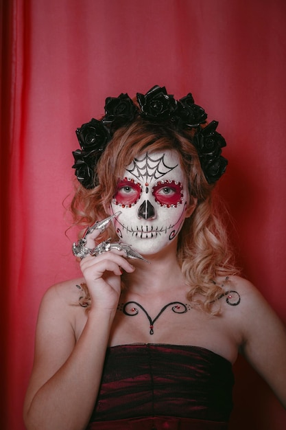 Beautiful woman with custom designed candy skull mexican day of\
the dead face make up halloween calavera catrina dia de los\
muertos