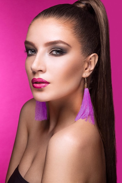 Beautiful woman with evening makeup bright accessories and long straight hair Smoky eyes Fashion photo