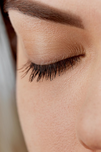 A beautiful woman with not extensible eyelashes in a beauty salon Eyelash extension procedure