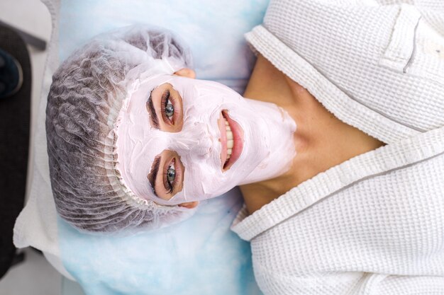 Foto bella donna con maschera facciale al salone di bellezza