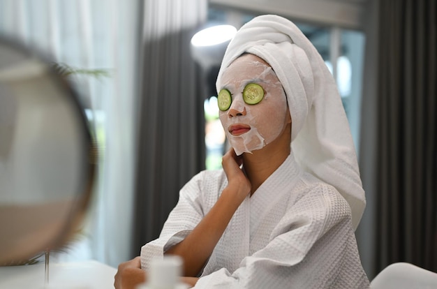 Photo beautiful woman with facial mask on her face and getting eye nature treatment by cucumber fresh cucumber beauty and self care