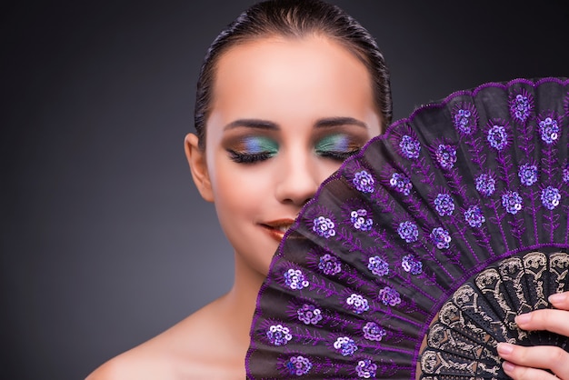 Beautiful woman with fan in fashion concept