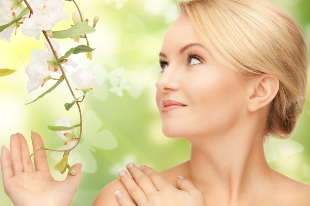 Foto bella donna con fiori su ramoscello e farfalle