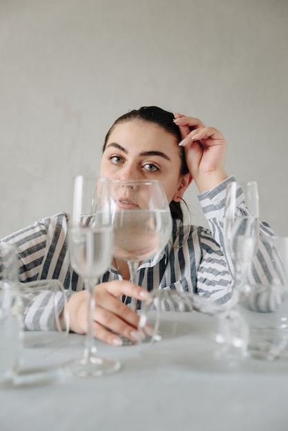 Beautiful woman with glasses of water on table