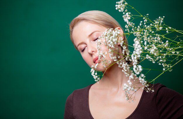 緑のシーンにカスミソウの花と美しい女性