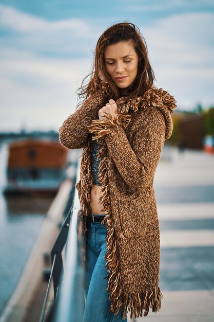 Photo beautiful woman with hand in hair standing by railing