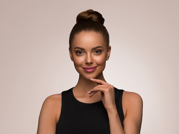 Beautiful woman with hands black dress classic bob hairstyle over color background pink