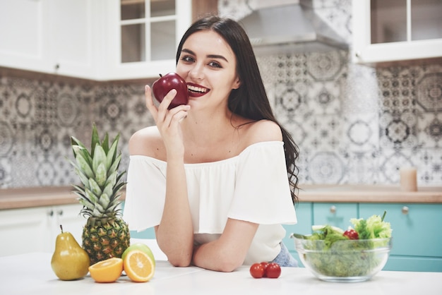 Beautiful woman with healthy food fruit in the kitchen.