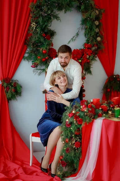 꽃으로 장식된 빨간 테이블에 사랑하는 남자와 함께 있는 아름다운 여자.