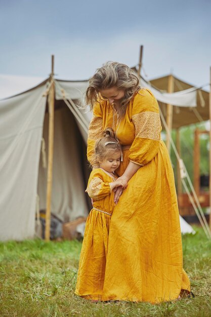 Beautiful woman with her daughter dressed in embroidered dresses