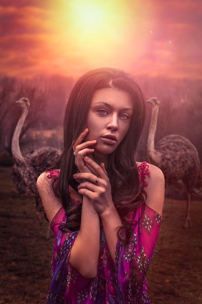 Beautiful woman with herd of ostriches
