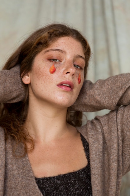 Photo beautiful woman with leaves on her face as drops