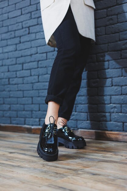 Beautiful woman with legs in fashionable clothes stylish leather black patent leather laceup shoes closeup Women's image in spring style