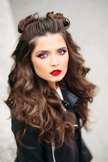 Beautiful woman with long curly hair in leather jacket.